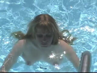 Nicely plump and beautifully busty woman takes off her bikini, striptease style, and then plays in the pool, jumping up and down on diving board for some lovely 'jiggly jugs' fan service footage.