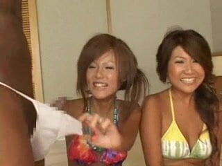 Two Japanese girls laugh at the two penis. One is a Japanese penis and the other is an American penis. The two girls compare the size and firmness of the two penis.